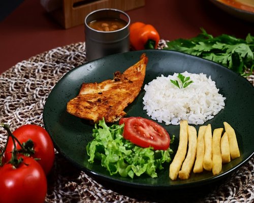 A well-portioned lunch plate presenting moderate white rice, dark red beans, cooked vegetables, and grilled chicken breast
